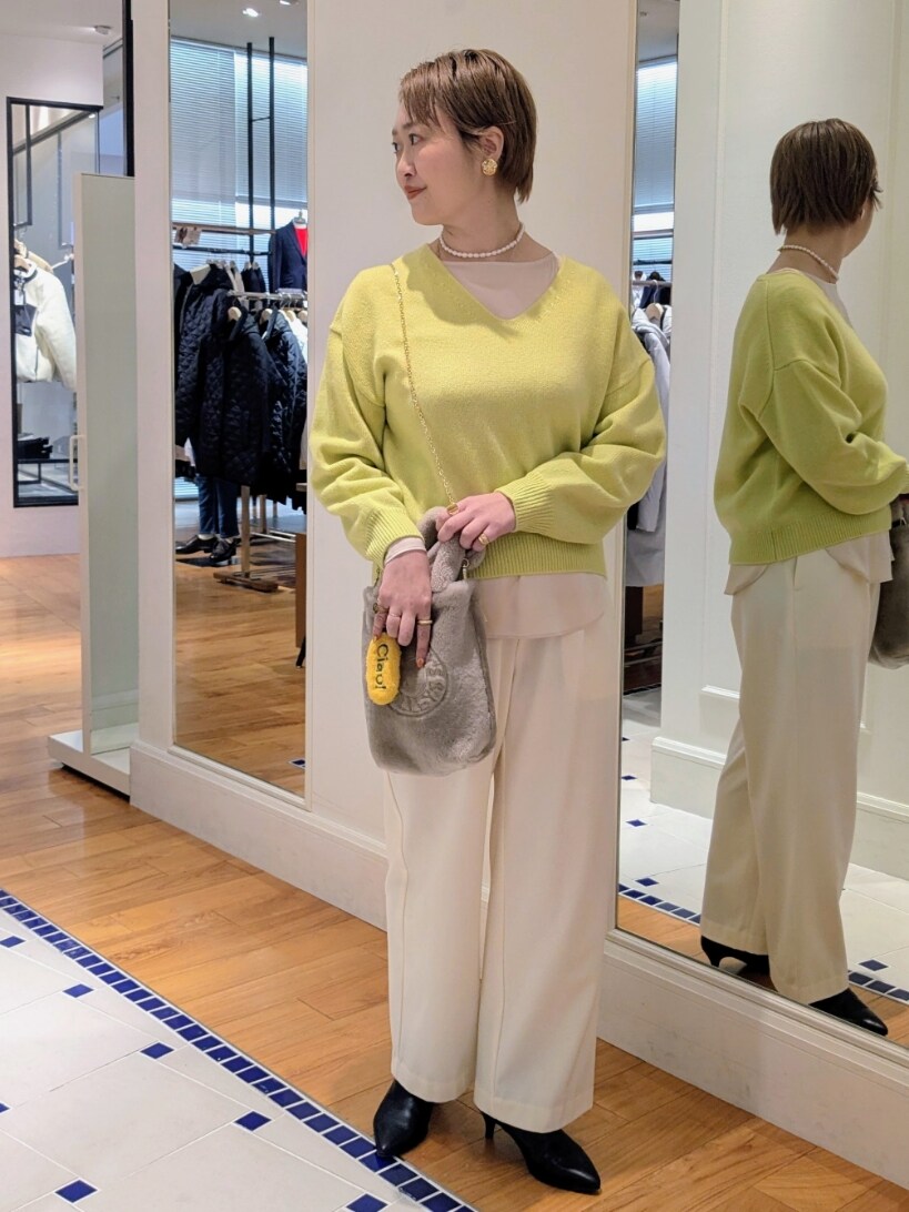 イエロー系のニット/セーター、ホワイト系のその他パンツ、ベージュ系のトートバッグを着用したレディースの冬コーディネートの3枚目の写真