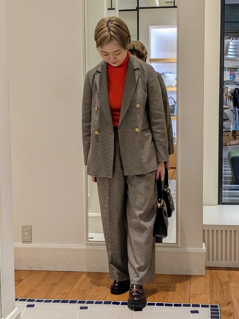 ベージュ系のテーラードジャケット、オレンジ系のニット/セーター、ブラウン系のその他パンツを着用したレディースの冬コーディネートの4枚目の写真