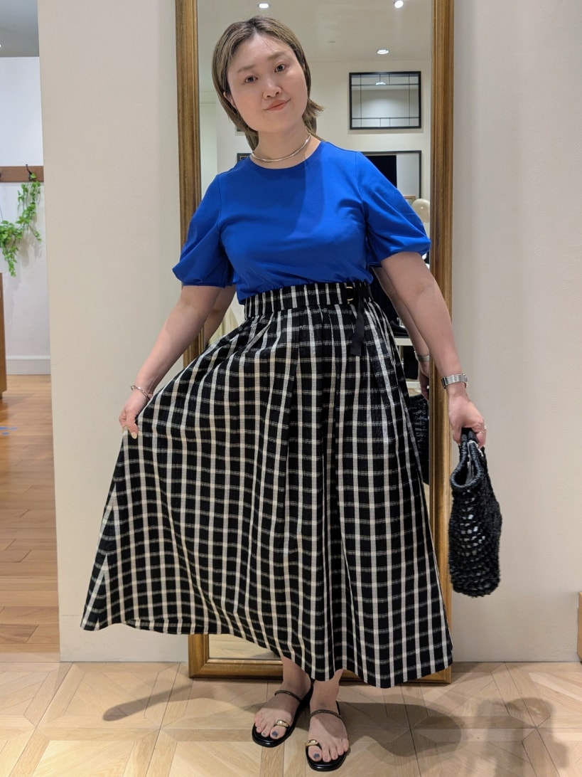 ブラック系のかごバッグ、ブラック系のスカート、ブルー系のTシャツ/カットソーを着用したレディースの春コーディネートの7枚目の写真