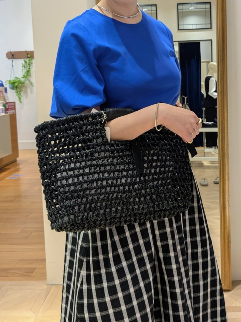 ブラック系のかごバッグ、ブラック系のスカート、ブルー系のTシャツ/カットソーを着用したレディースの春コーディネートの4枚目の写真