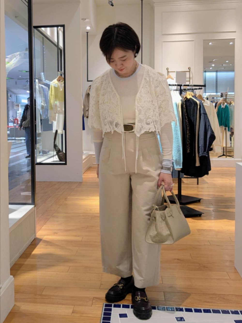 ベージュ系のトートバッグ、グレー系のネックレス、シルバー系のピアス（両耳用）を着用したレディースの冬コーディネートの2枚目の写真