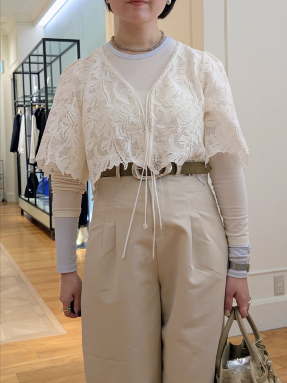 ベージュ系のトートバッグ、グレー系のネックレス、シルバー系のピアス（両耳用）を着用したレディースの冬コーディネートの4枚目の写真