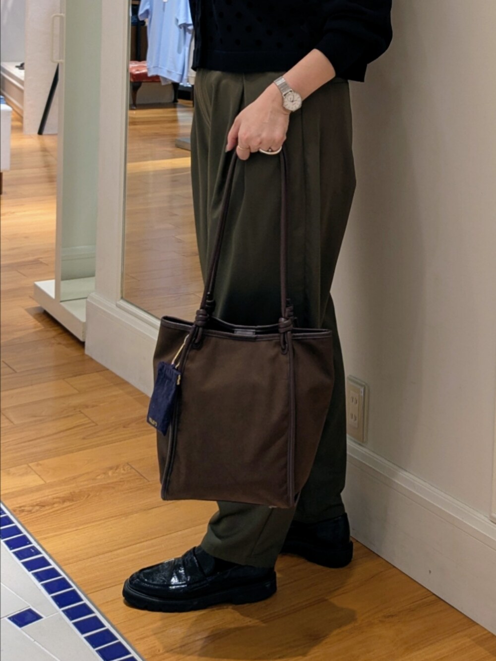 ブラック系のカーディガン/ボレロ、グリーン系のチノパンツ、ブラック系のドレスシューズを着用したレディースの夏コーディネートの8枚目の写真