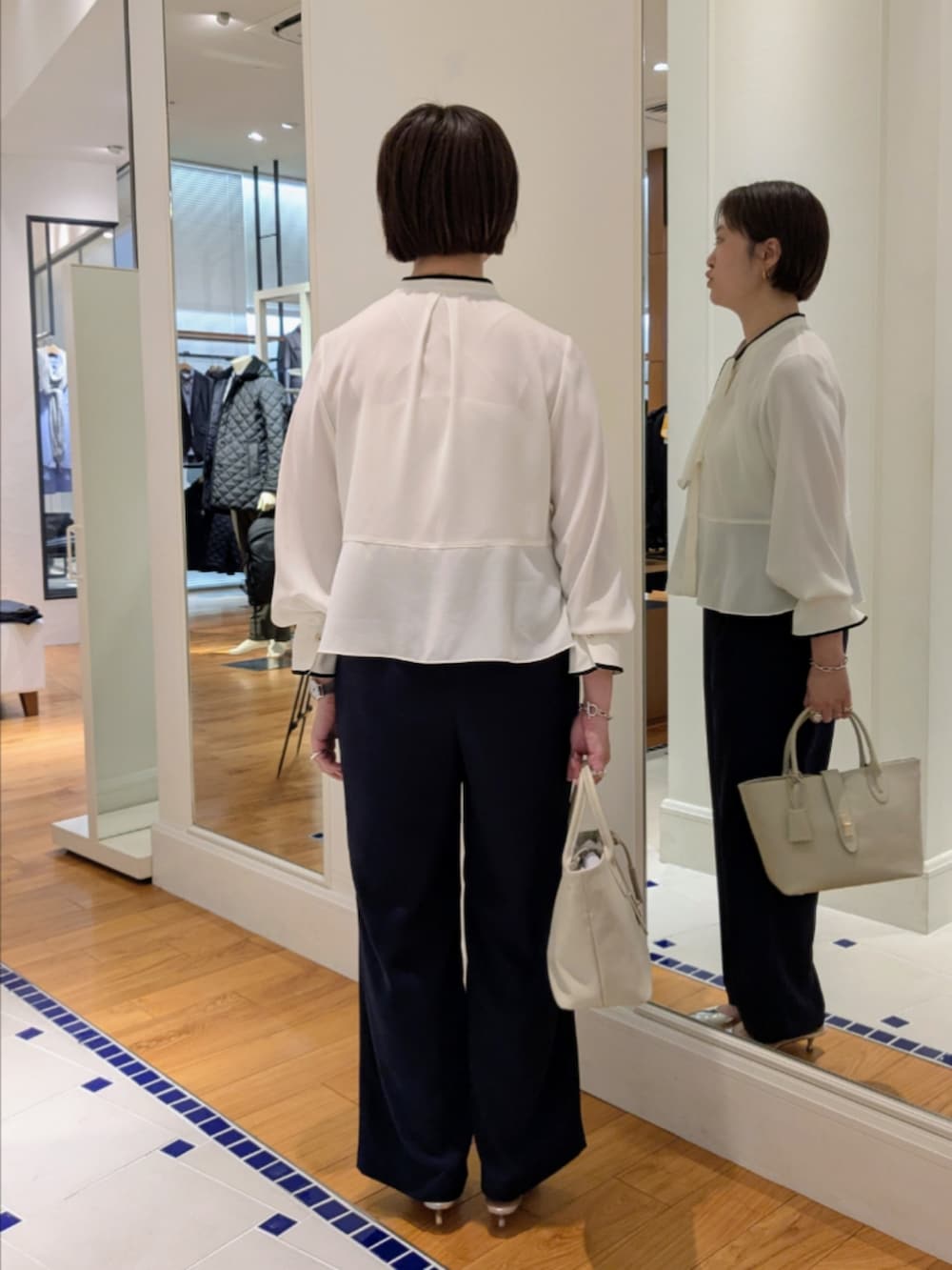 ホワイト系のシャツ/ブラウス、ブラック系のノーカラージャケット、ブルー系のその他パンツを着用したレディースの冬コーディネートの10枚目の写真