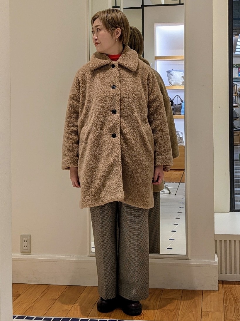 イエロー系のダッフルコート、オレンジ系のニット/セーター、ブラウン系のその他パンツを着用したレディースの冬コーディネートの8枚目の写真