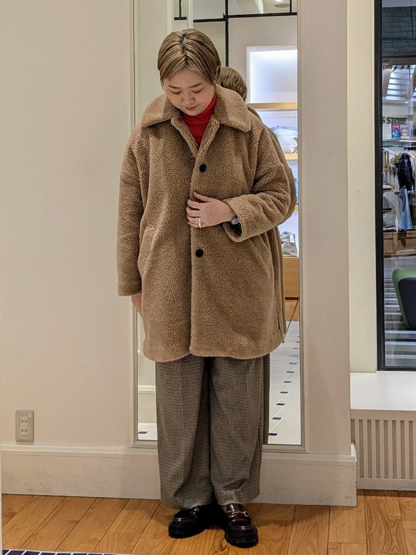 イエロー系のダッフルコート、オレンジ系のニット/セーター、ブラウン系のその他パンツを着用したレディースの冬コーディネートの4枚目の写真