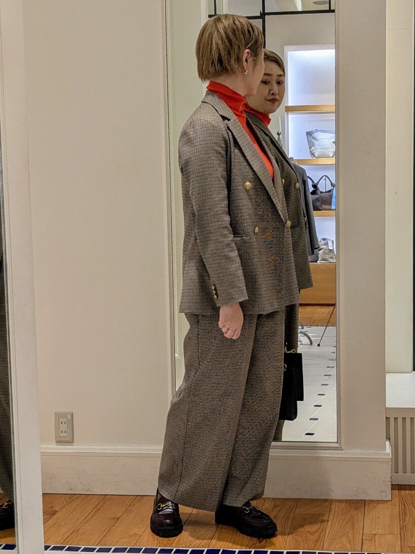 ベージュ系のテーラードジャケット、オレンジ系のニット/セーター、ブラウン系のその他パンツを着用したレディースの冬コーディネートの6枚目の写真