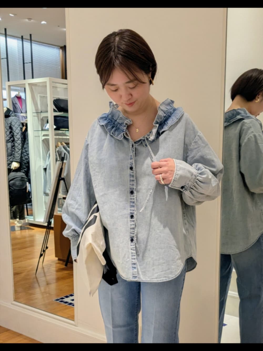 ブルー系のデニムパンツ、ブルー系のシャツ/ブラウス、ホワイト系のトートバッグを着用したレディースの冬コーディネートの5枚目の写真