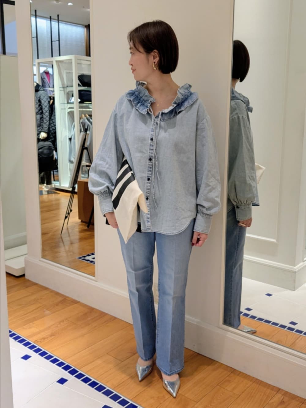 ブルー系のデニムパンツ、ブルー系のシャツ/ブラウス、ホワイト系のトートバッグを着用したレディースの冬コーディネートの4枚目の写真