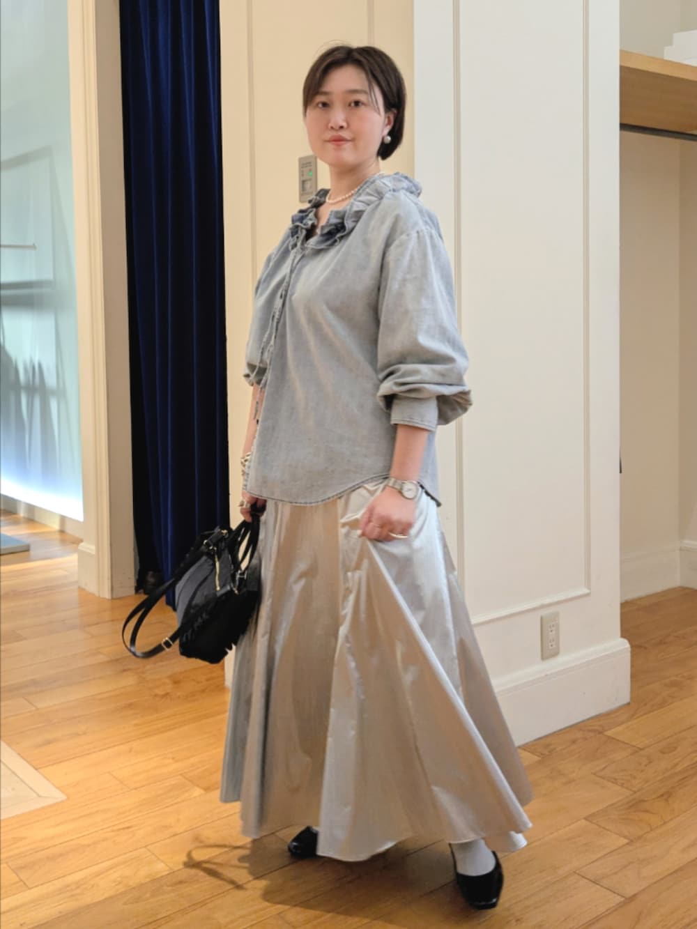 シルバー系のスカート、ブルー系のシャツ/ブラウス、ブラック系のショルダーバッグを着用したレディースの冬コーディネートの7枚目の写真