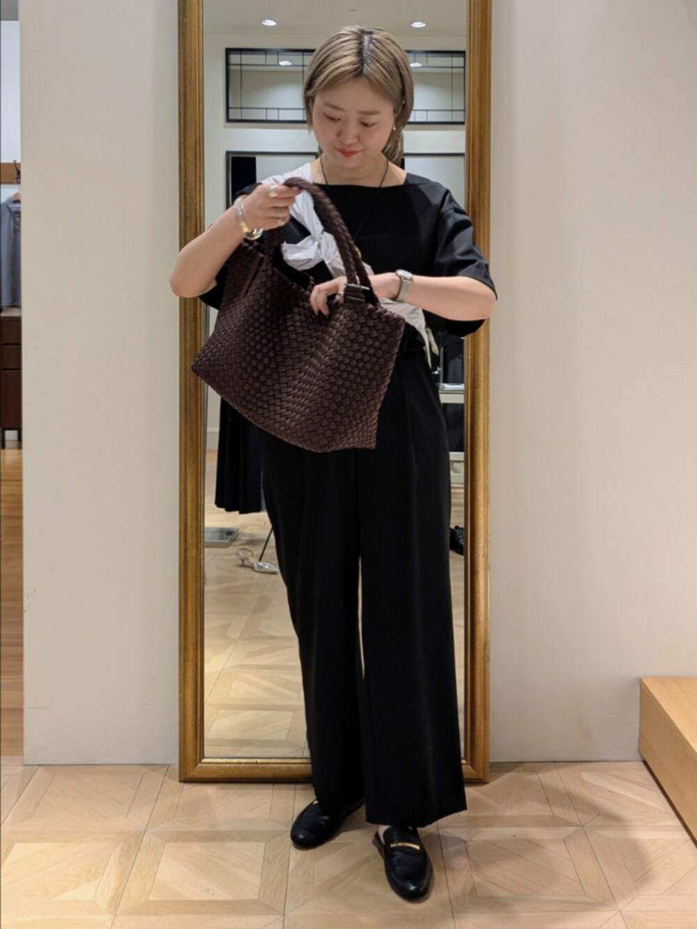 ブラウン系のトートバッグ、ブラック系のシャツ/ブラウス、ブラック系のその他パンツを着用したレディースの春コーディネートの3枚目の写真