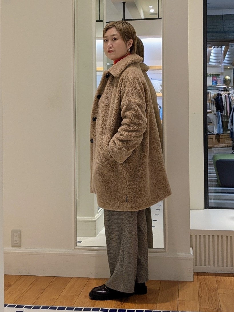 イエロー系のダッフルコート、オレンジ系のニット/セーター、ブラウン系のその他パンツを着用したレディースの冬コーディネートの5枚目の写真