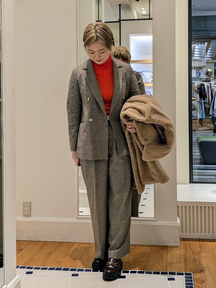 イエロー系のダッフルコート、オレンジ系のニット/セーター、ブラウン系のその他パンツを着用したレディースの冬コーディネートの9枚目の写真