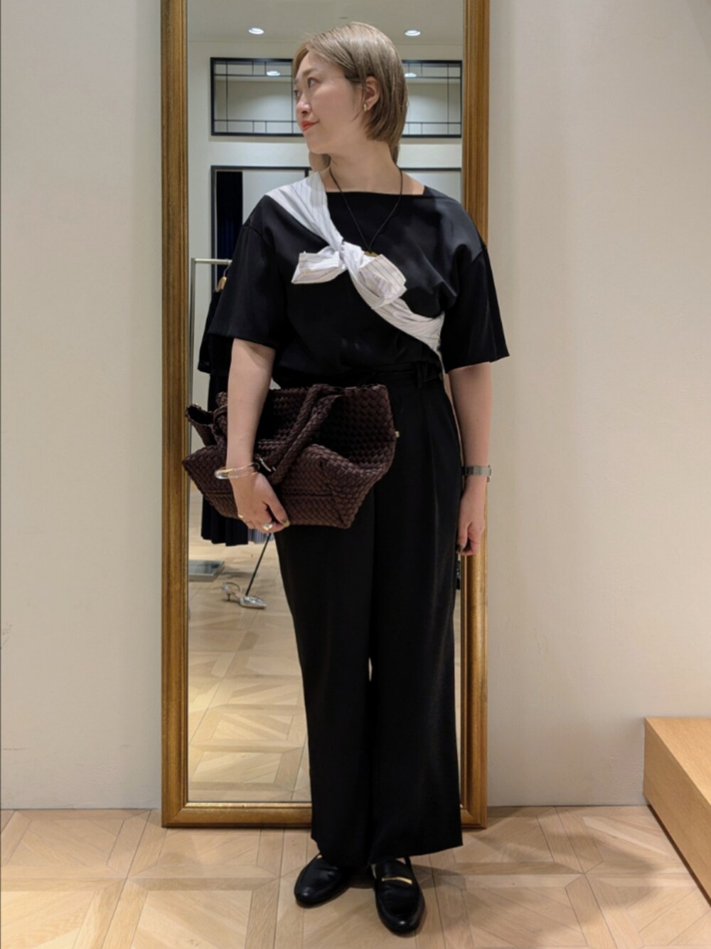 ブラウン系のトートバッグ、ブラック系のシャツ/ブラウス、ブラック系のその他パンツを着用したレディースの春コーディネートの10枚目の写真