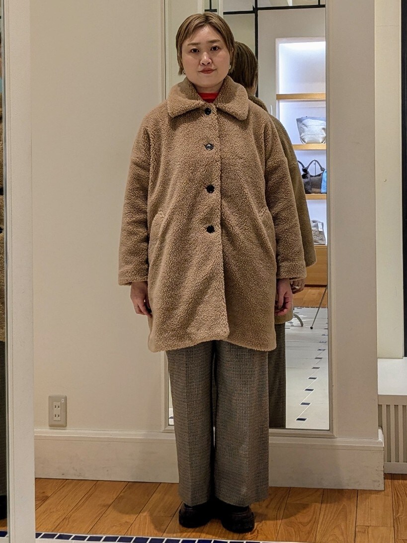 イエロー系のダッフルコート、オレンジ系のニット/セーター、ブラウン系のその他パンツを着用したレディースの冬コーディネートの7枚目の写真