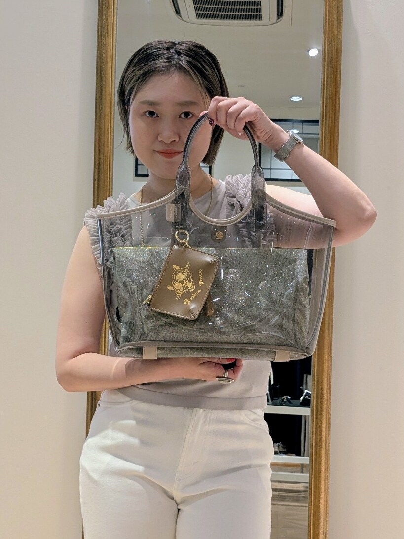 ベージュ系のニット/セーター、ホワイト系のデニムパンツ、ベージュ系のトートバッグを着用したレディースの夏コーディネートの3枚目の写真