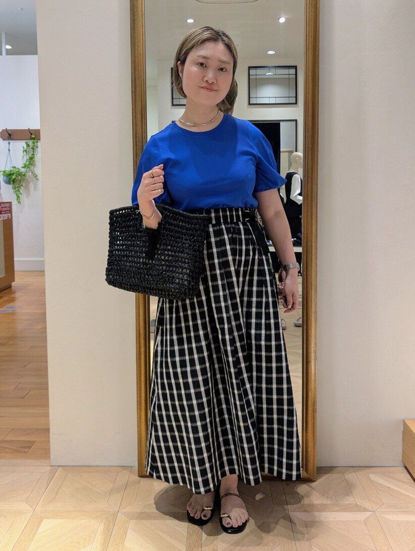 ブラック系のかごバッグ、ブラック系のスカート、ブルー系のTシャツ/カットソーを着用したレディースの春コーディネートの2枚目の写真