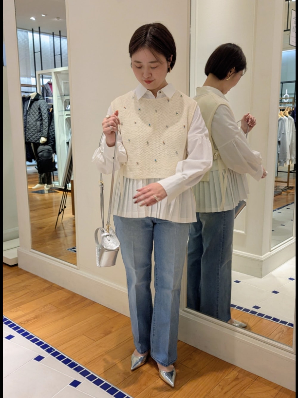 ホワイト系のシャツ/ブラウス、ホワイト系のベスト、シルバー系のショルダーバッグを着用したレディースの冬コーディネートの2枚目の写真