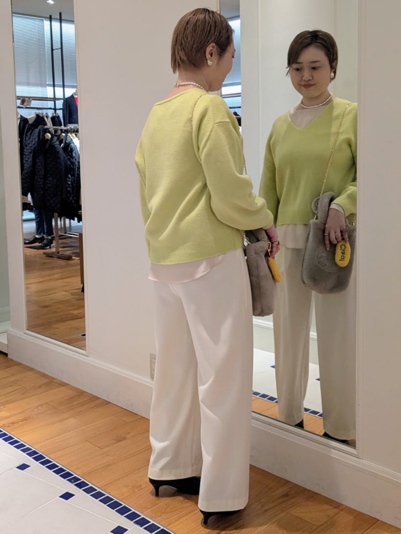 イエロー系のニット/セーター、ホワイト系のその他パンツ、ベージュ系のトートバッグを着用したレディースの冬コーディネートの4枚目の写真