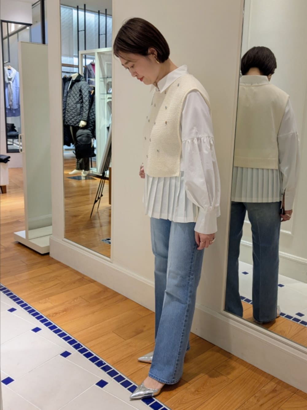 ホワイト系のシャツ/ブラウス、ホワイト系のベスト、シルバー系のショルダーバッグを着用したレディースの冬コーディネートの7枚目の写真