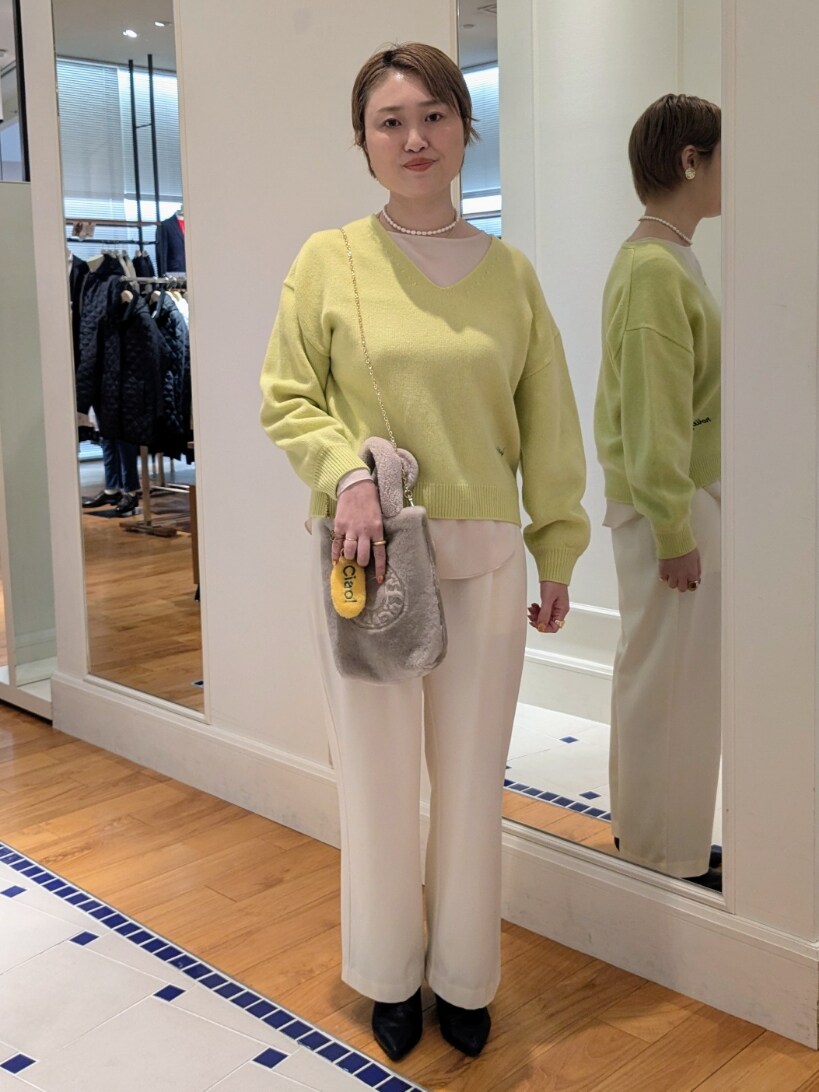 イエロー系のニット/セーター、ホワイト系のその他パンツ、ベージュ系のトートバッグを着用したレディースの冬コーディネートの8枚目の写真