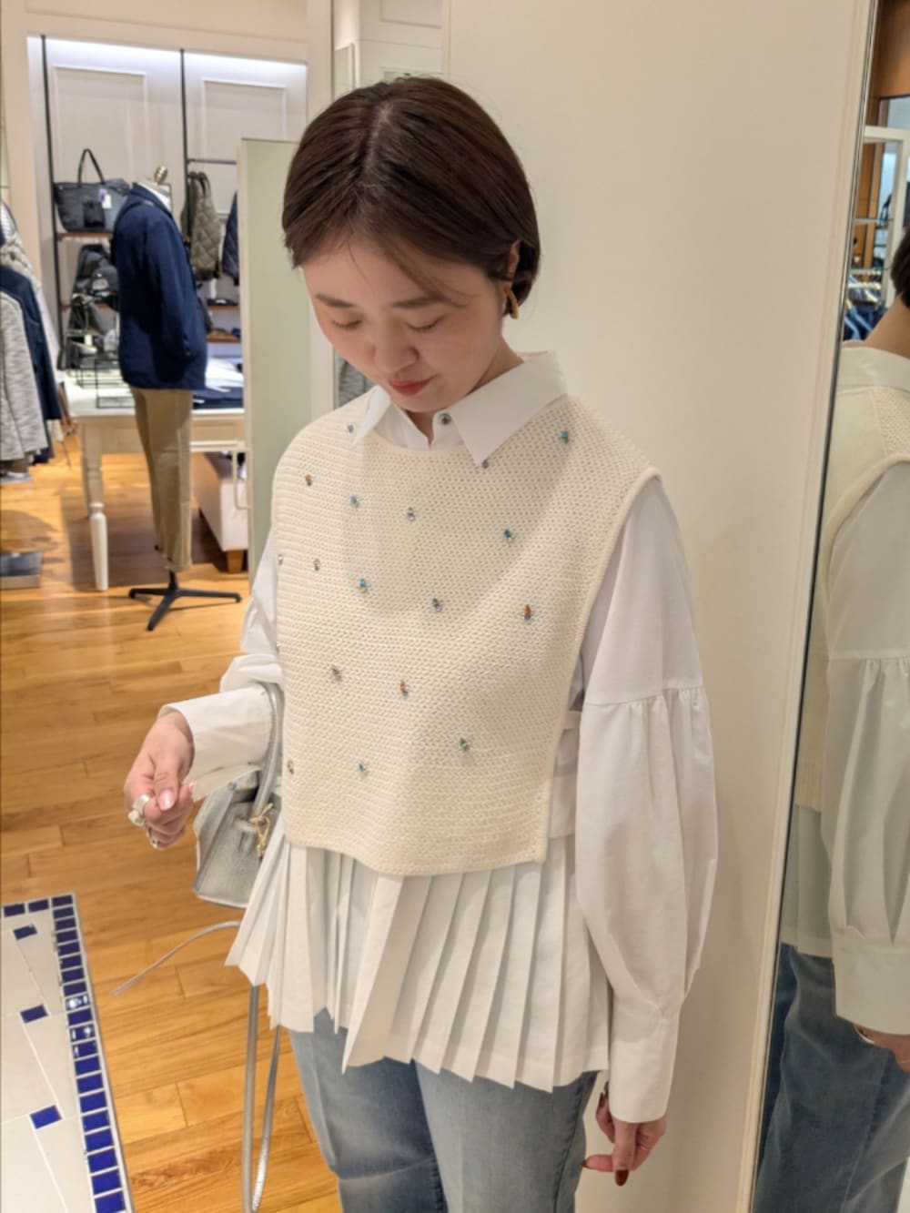 ホワイト系のシャツ/ブラウス、ホワイト系のベスト、シルバー系のショルダーバッグを着用したレディースの冬コーディネートの4枚目の写真