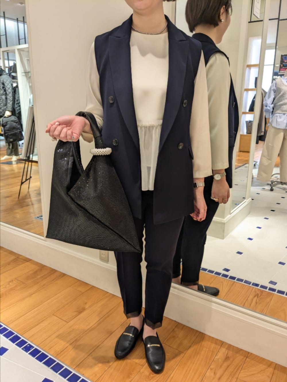 ホワイト系のシャツ/ブラウス、ブルー系のベスト、ブラック系のショルダーバッグを着用したレディースの冬コーディネートの10枚目の写真