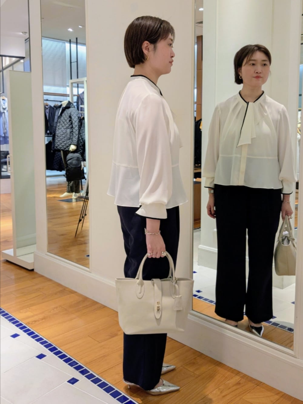 ホワイト系のシャツ/ブラウス、ブラック系のノーカラージャケット、ブルー系のその他パンツを着用したレディースの冬コーディネートの9枚目の写真