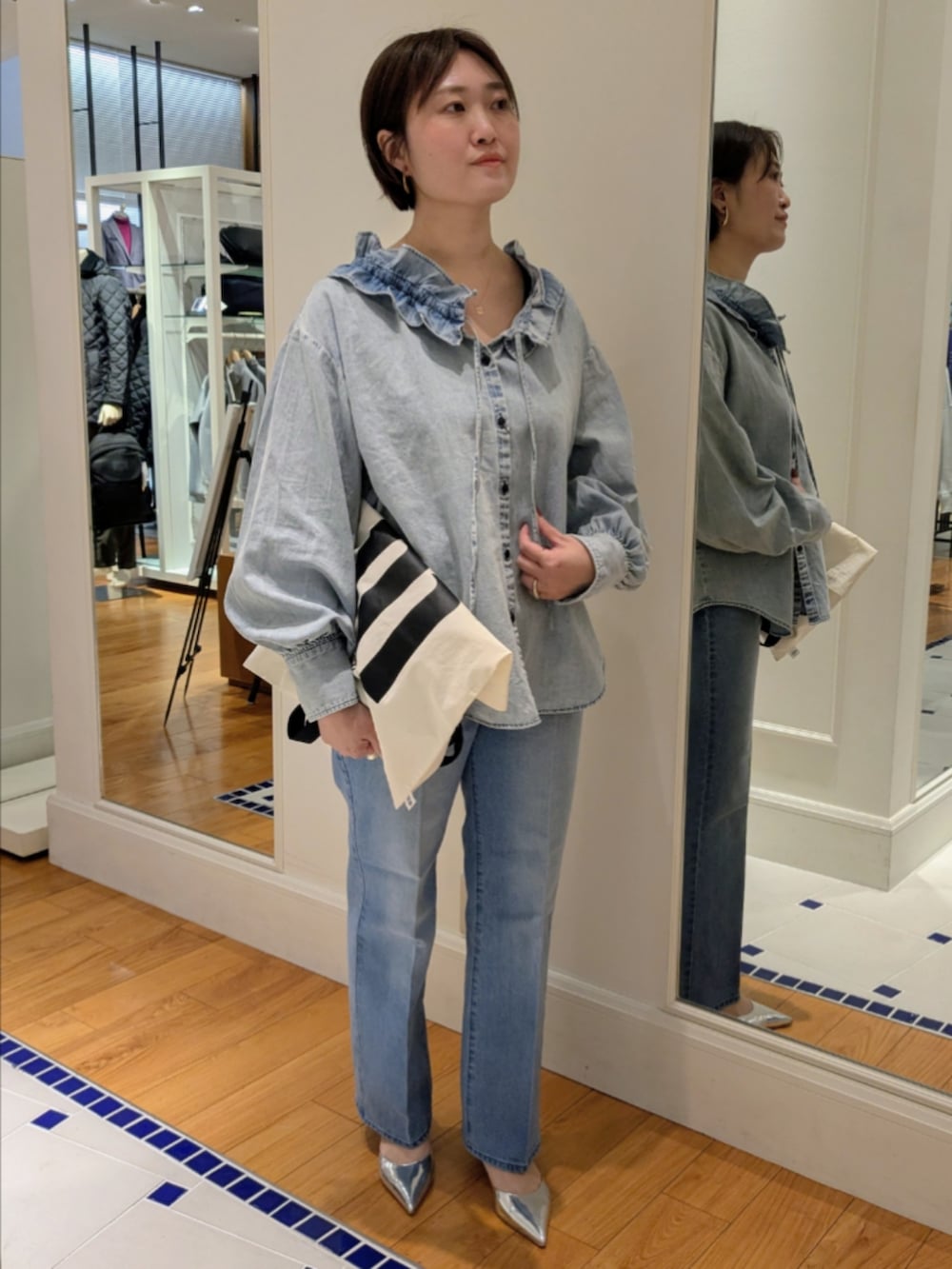 ブルー系のデニムパンツ、ブルー系のシャツ/ブラウス、ホワイト系のトートバッグを着用したレディースの冬コーディネートの8枚目の写真