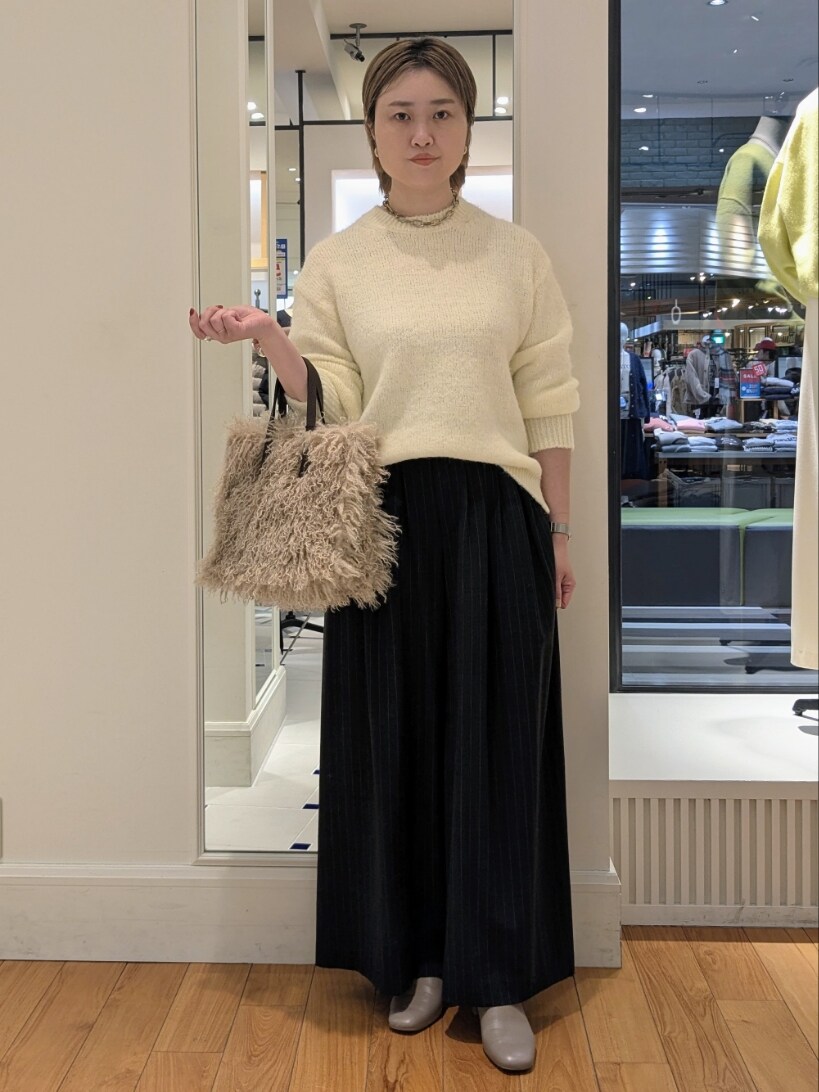 ベージュ系のニット/セーター、ベージュ系のショルダーバッグ、ブラック系のその他パンツを着用したレディースの冬コーディネートの2枚目の写真