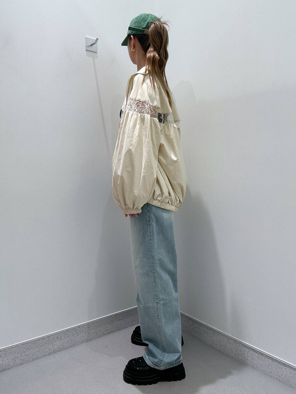 ホワイト系のブルゾン、ブルー系のデニムパンツ、ブラック系のローファーを着用したレディースの冬コーディネートの2枚目の写真