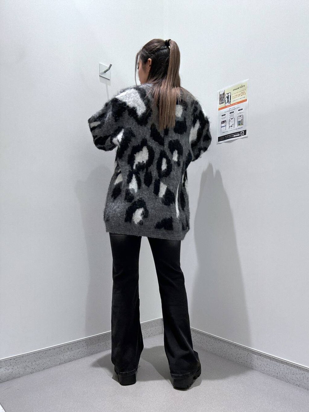 ブラウン系のローファー、ブラック系のデニムパンツ、グレー系のチュニックを着用したレディースの冬コーディネートの2枚目の写真
