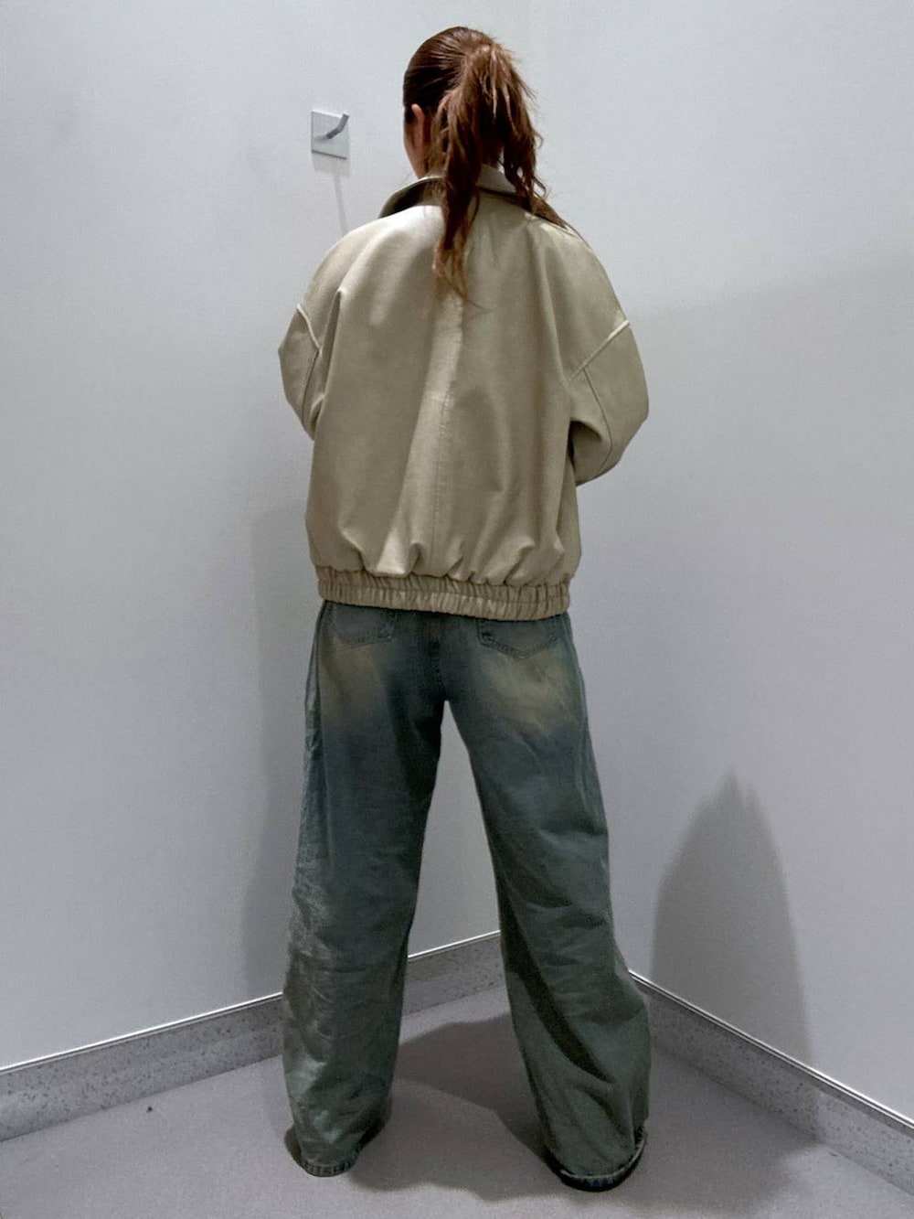 ブルー系のデニムパンツ、ブラウン系のローファー、ブラック系のTシャツ/カットソーを着用したレディースの冬コーディネートの3枚目の写真