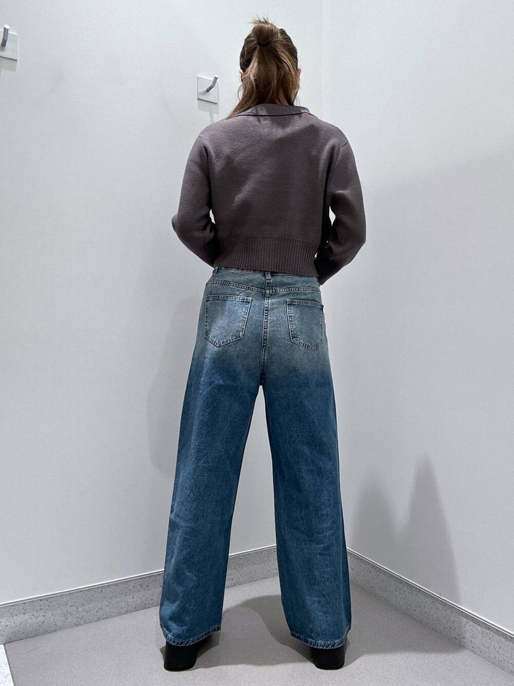 ブラック系のスリッポン、グレー系のカーディガン/ボレロ、ブルー系のデニムパンツを着用したレディースの冬コーディネートの3枚目の写真