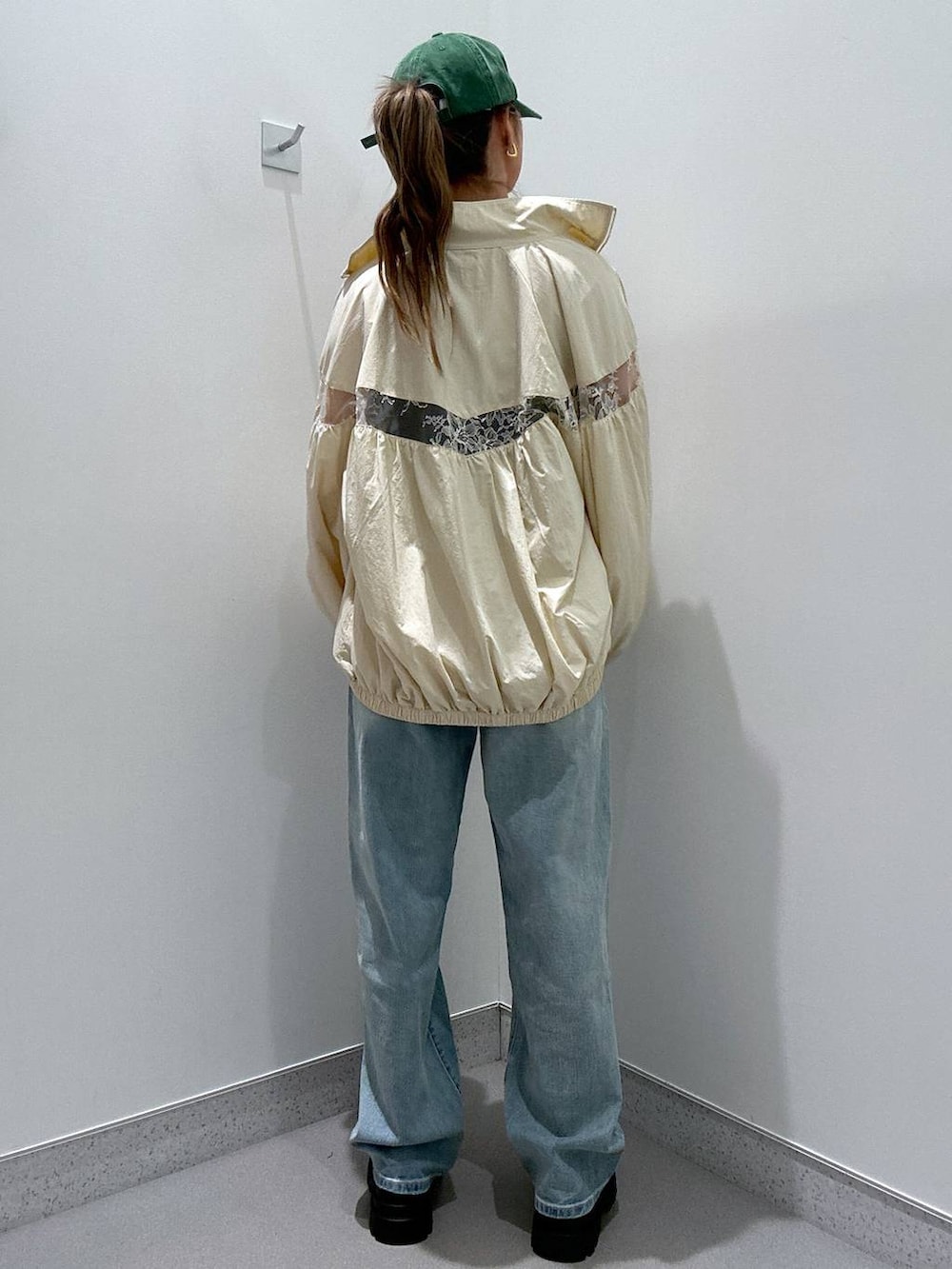 ホワイト系のブルゾン、ブルー系のデニムパンツ、ブラック系のローファーを着用したレディースの冬コーディネートの3枚目の写真