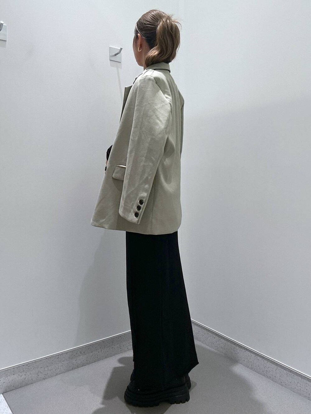 ブラック系のローファー、ブラック系のハンドバッグ、ブラック系のスカートを着用したレディースの冬コーディネートの2枚目の写真