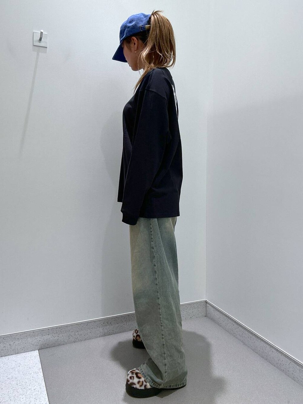 ブルー系のデニムパンツ、ベージュ系のスリッポン、ブラック系のTシャツ/カットソーを着用したレディースの冬コーディネートの2枚目の写真