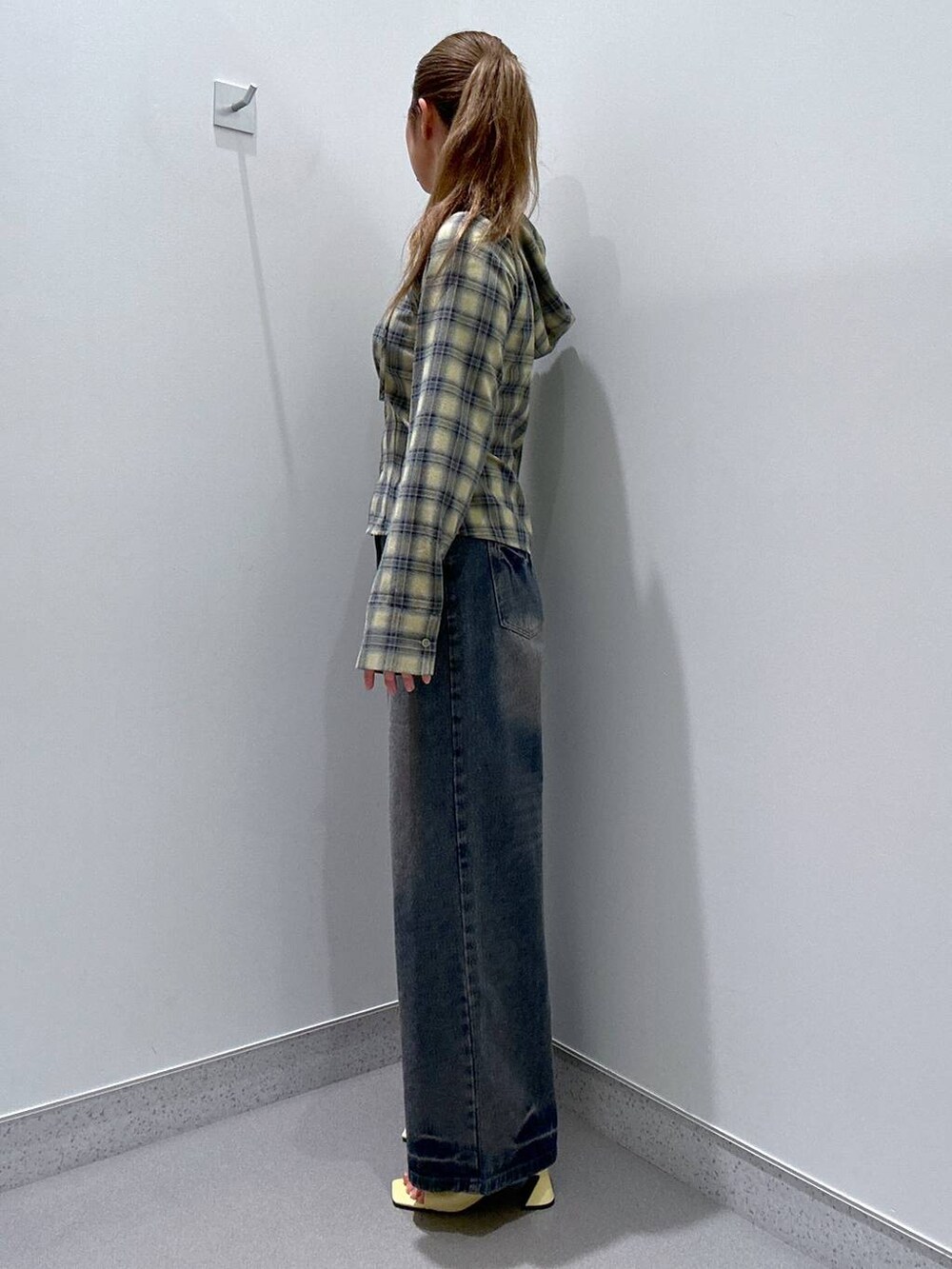 イエロー系のサンダル、ブルー系のデニムパンツ、ブルー系のシャツ/ブラウスを着用したレディースの冬コーディネートの2枚目の写真