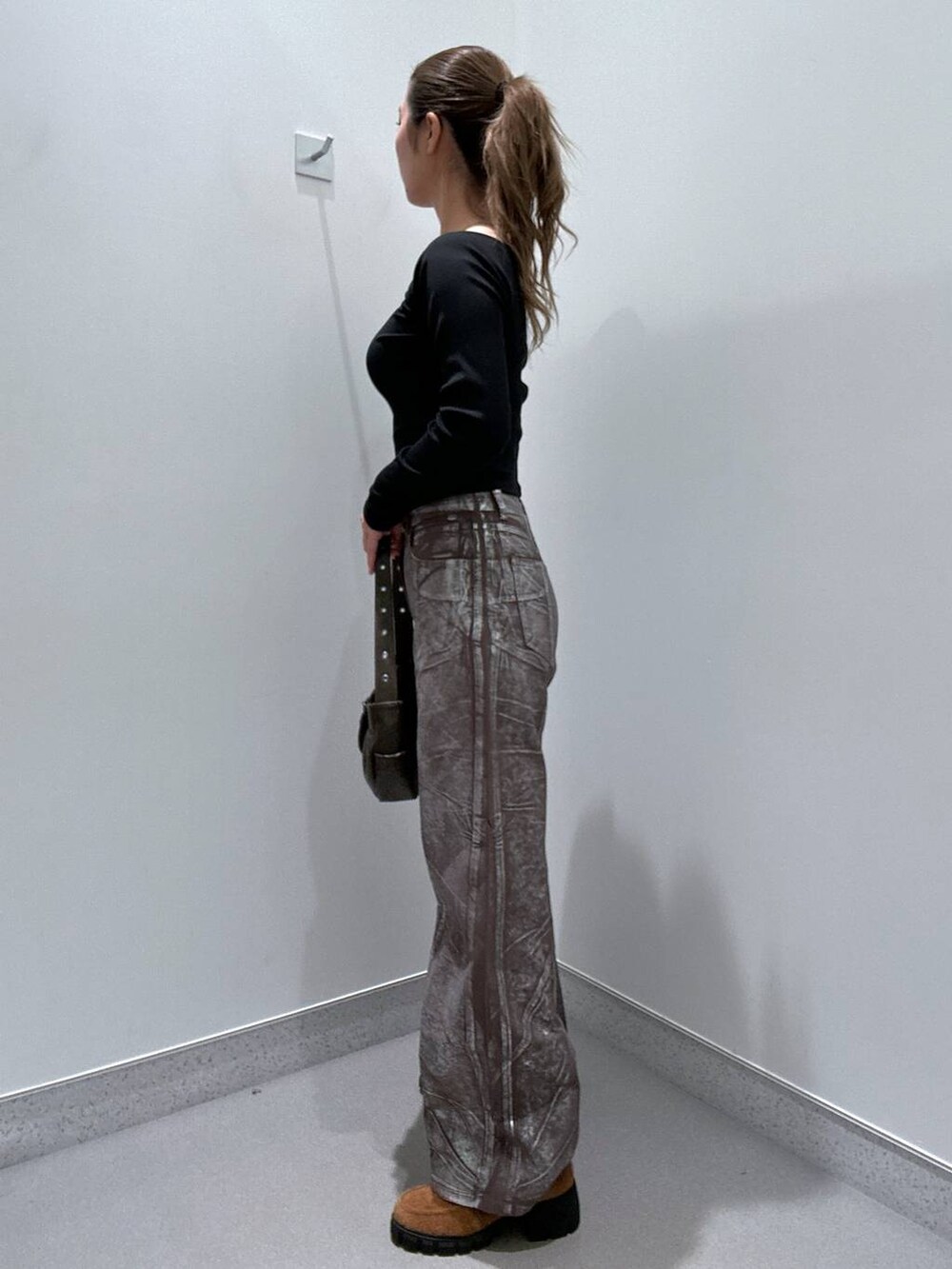 ブラウン系のデニムパンツ、ブラウン系のローファー、ブラック系のTシャツ/カットソーを着用したレディースの冬コーディネートの2枚目の写真