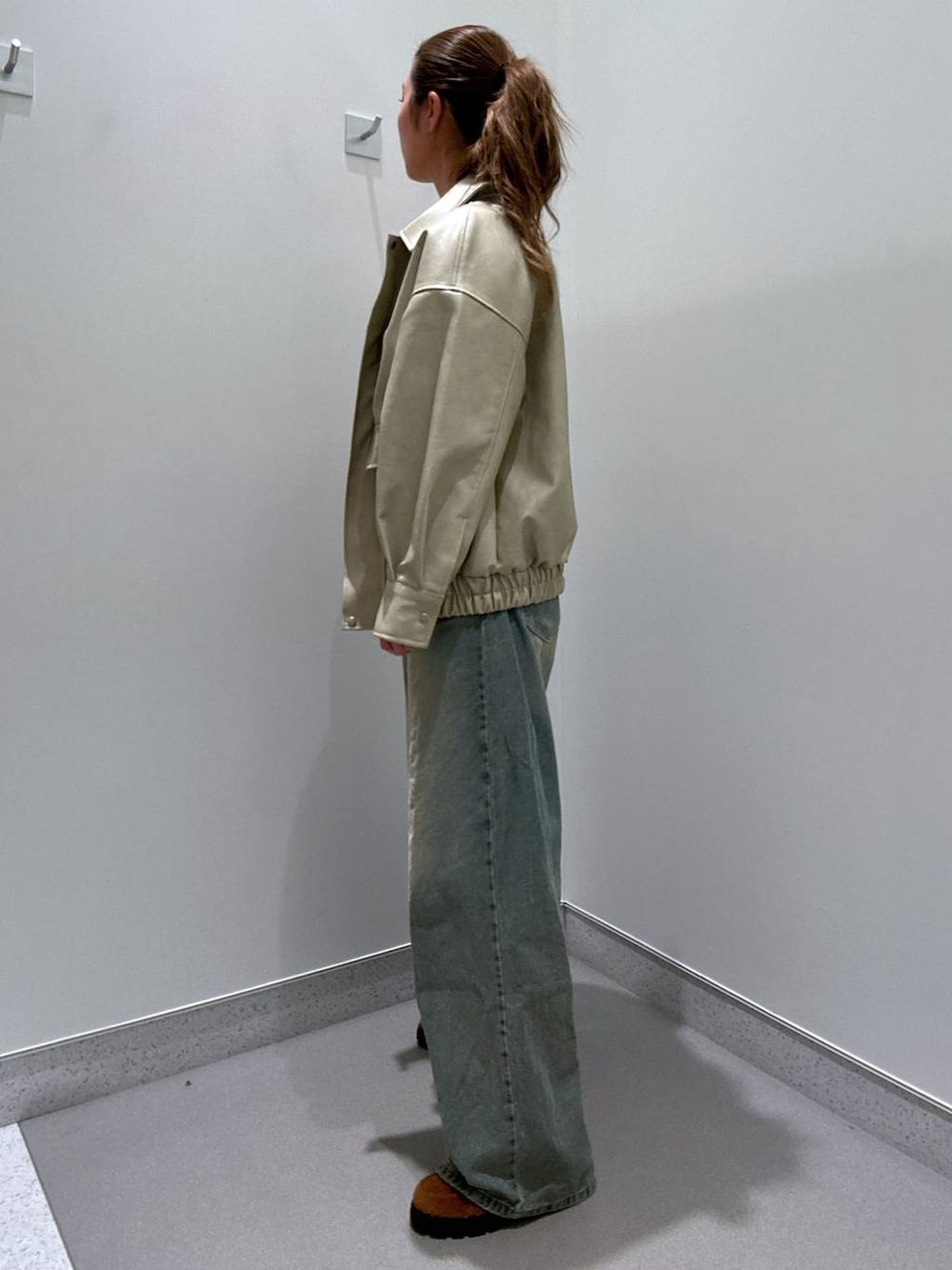 ブルー系のデニムパンツ、ブラウン系のローファー、ブラック系のTシャツ/カットソーを着用したレディースの冬コーディネートの2枚目の写真