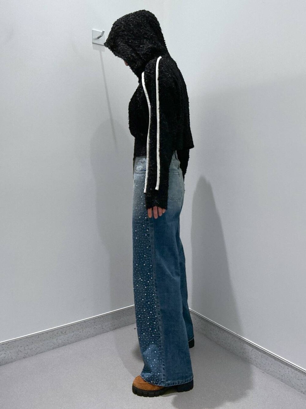 ブルー系のデニムパンツ、ブラック系のカーディガン/ボレロ、ブラウン系のローファーを着用したレディースの冬コーディネートの2枚目の写真