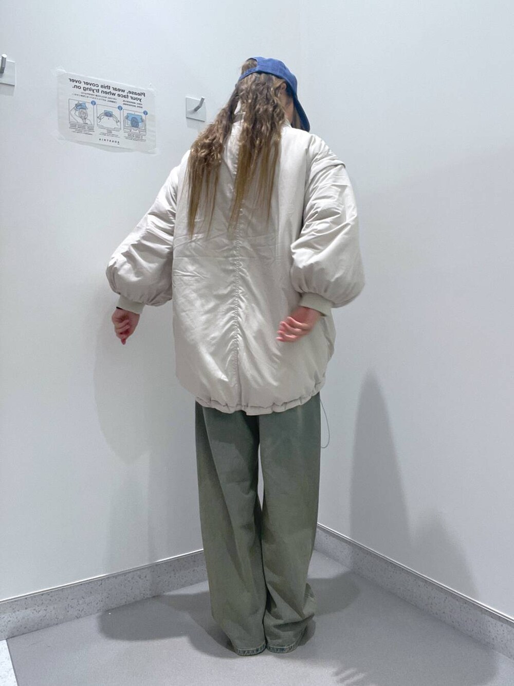 ホワイト系のブルゾン、ブルー系のデニムパンツ、ベージュ系のスリッポンを着用したレディースの冬コーディネートの3枚目の写真