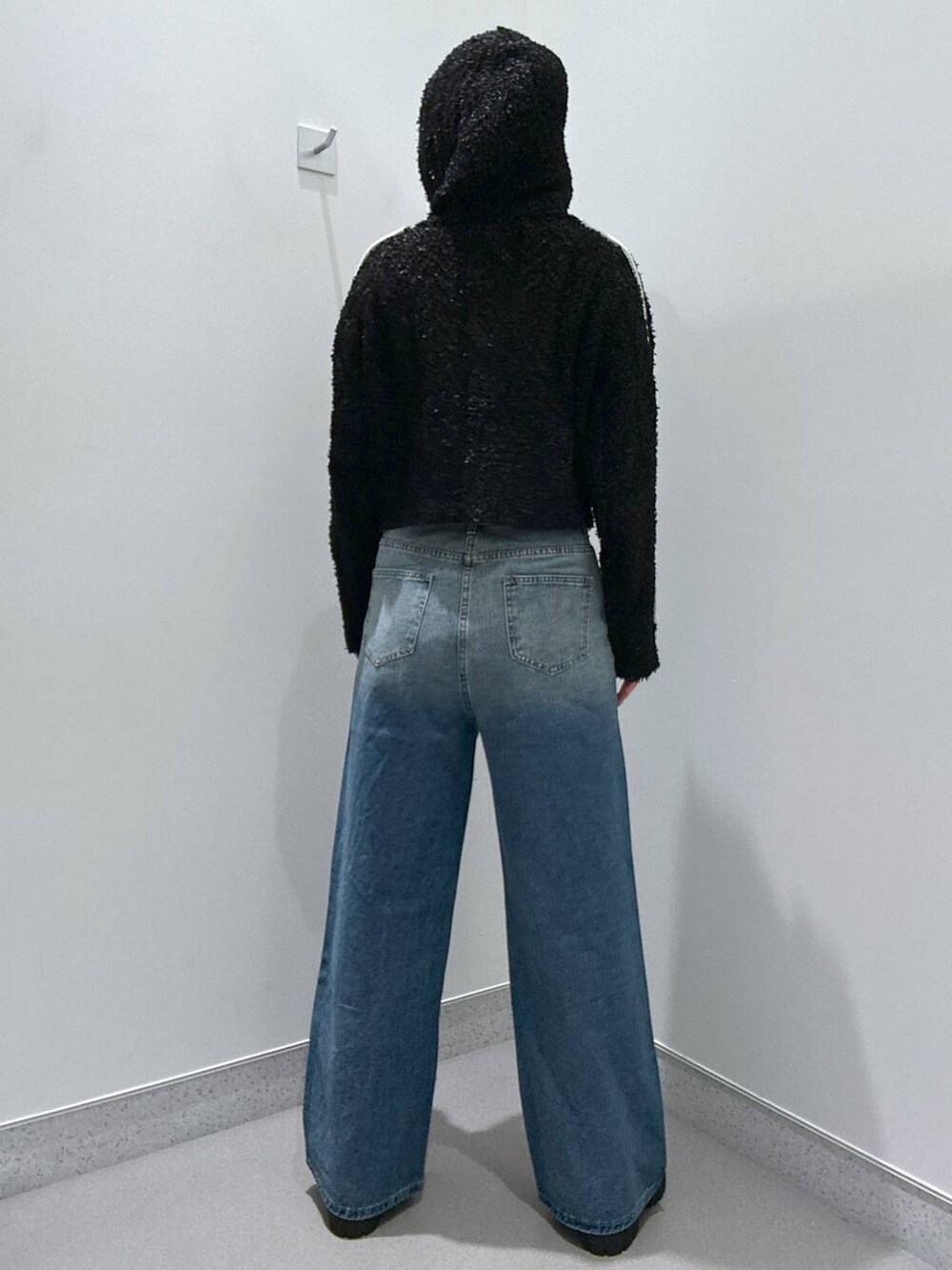 ブルー系のデニムパンツ、ブラック系のカーディガン/ボレロ、ブラウン系のローファーを着用したレディースの冬コーディネートの3枚目の写真