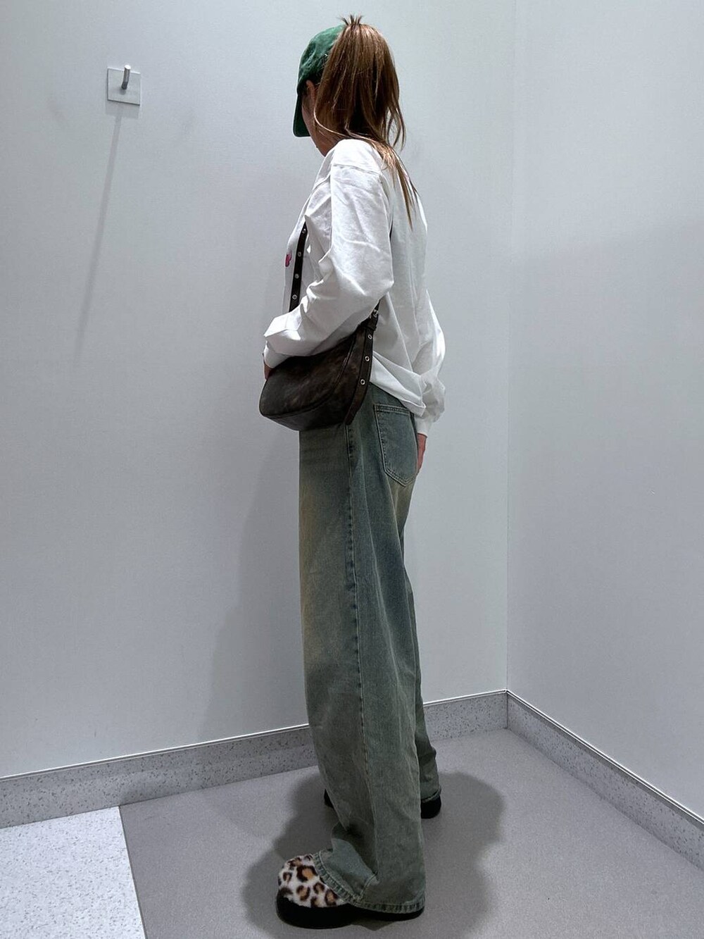 ブルー系のデニムパンツ、ベージュ系のスリッポン、ホワイト系のTシャツ/カットソーを着用したレディースの冬コーディネートの2枚目の写真