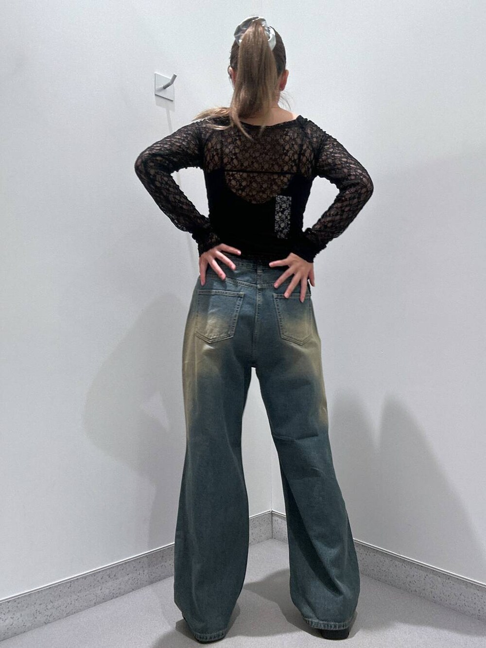 ブルー系のデニムパンツ、ブラック系のローファー、ブラック系のキャミソールを着用したレディースの冬コーディネートの3枚目の写真