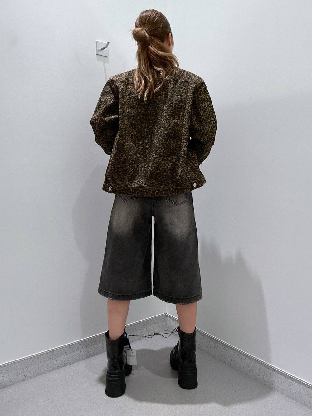 ブラック系のデニムパンツ、ブラウン系のブルゾン、ブラック系のTシャツ/カットソーを着用したレディースの冬コーディネートの3枚目の写真