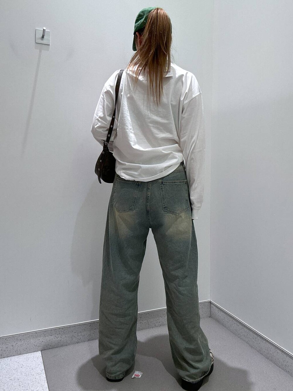 ブルー系のデニムパンツ、ベージュ系のスリッポン、ホワイト系のTシャツ/カットソーを着用したレディースの冬コーディネートの3枚目の写真