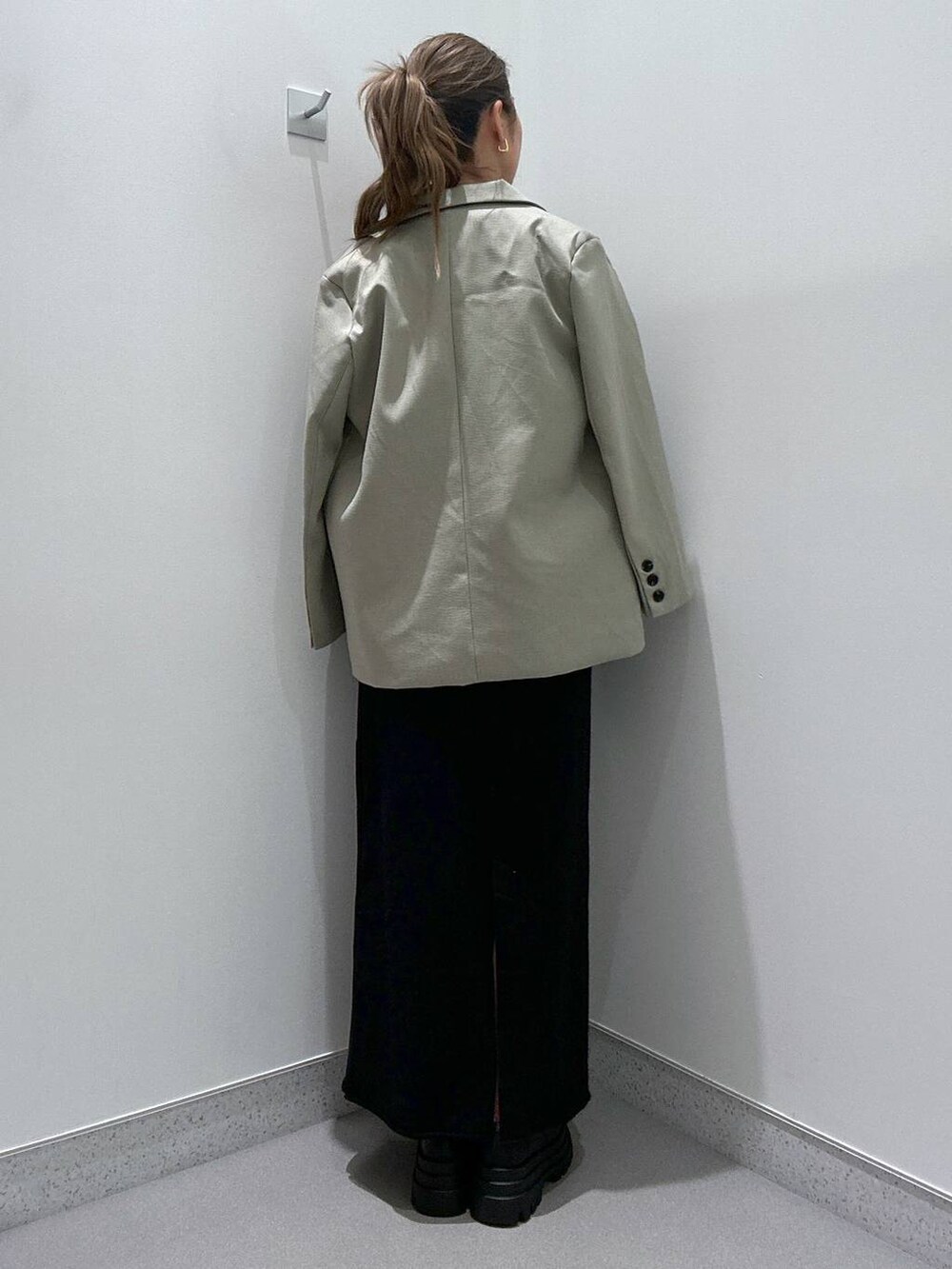 ブラック系のローファー、ブラック系のハンドバッグ、ブラック系のスカートを着用したレディースの冬コーディネートの3枚目の写真