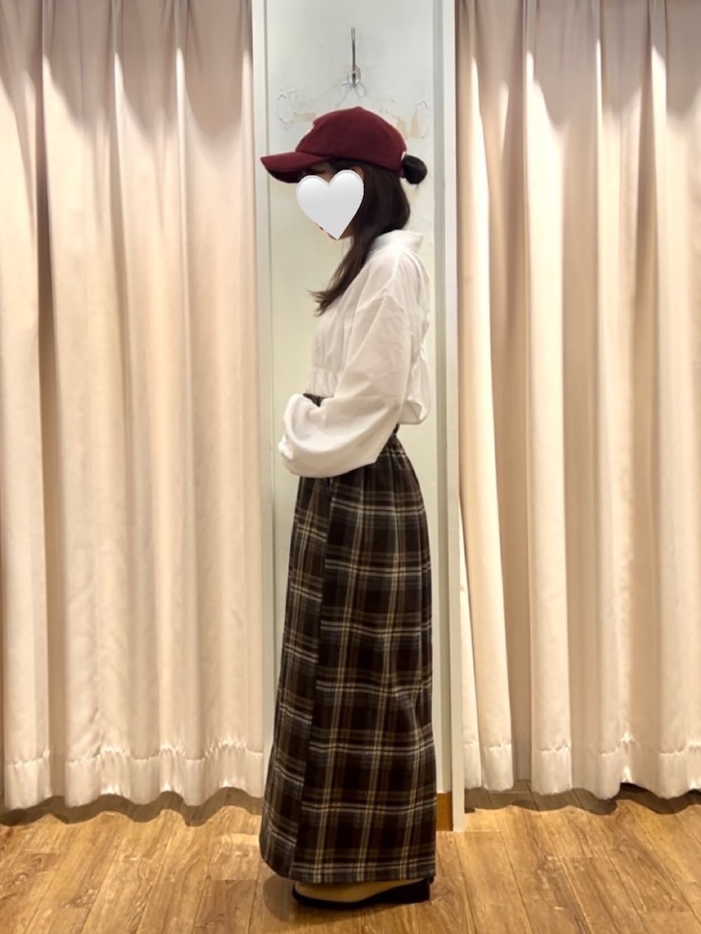 ブラウン系のスカート、ベージュ系のブーツ、ホワイト系のシャツ/ブラウスを着用したレディースの秋コーディネートの2枚目の写真