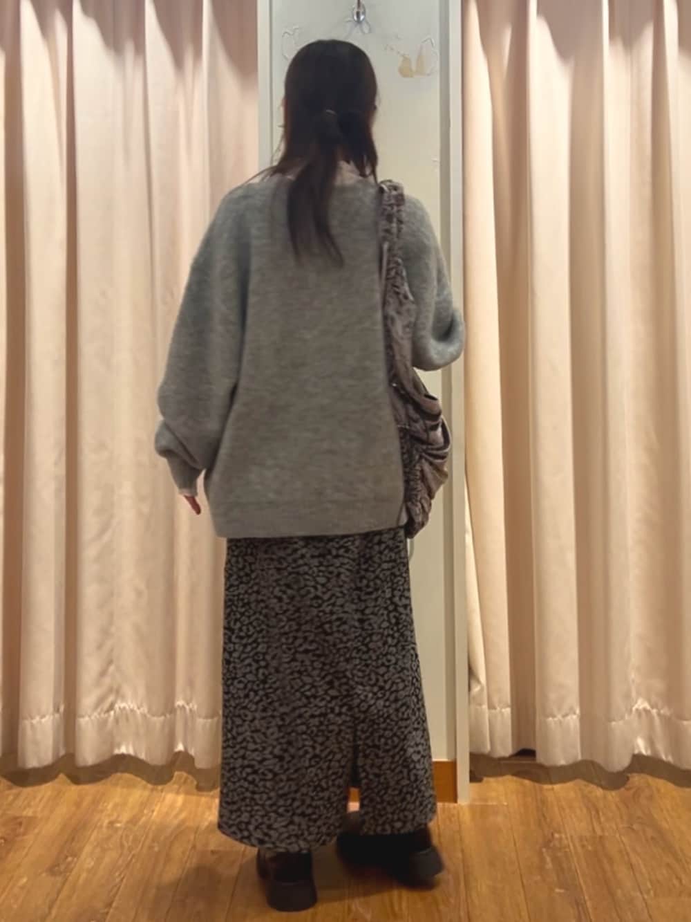 グレー系のカーディガン/ボレロ、ホワイト系のTシャツ/カットソー、ブラック系のスカートを着用したレディースの冬コーディネートの3枚目の写真